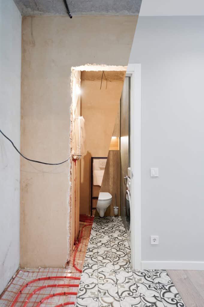 Rénovation de salle de bain avant-après: gauche, murs bruts et chauffage au sol; droite, WC moderne, carrelage et machine à laver.
